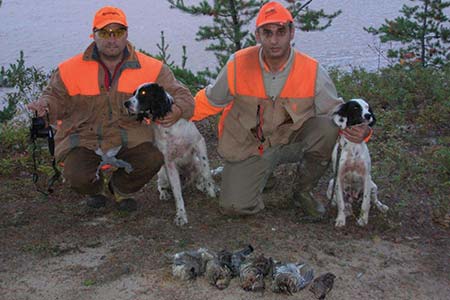 Deux chasseurs posés avec leurs chiens de chasses et les perdrix qu'ils ont abattu